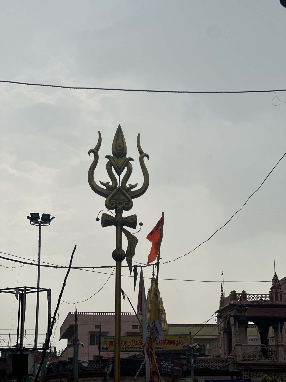 A tall trishul against the sky in Kashi.