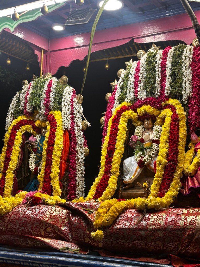 Temple deities adorned with flower garlands