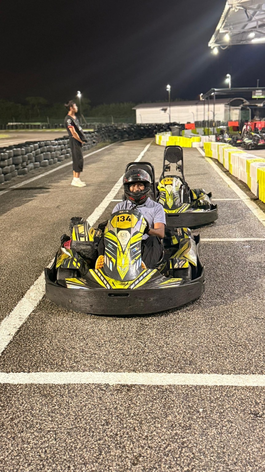 Thana wearing a helmet in go-kart number 134 at Sepang at night
