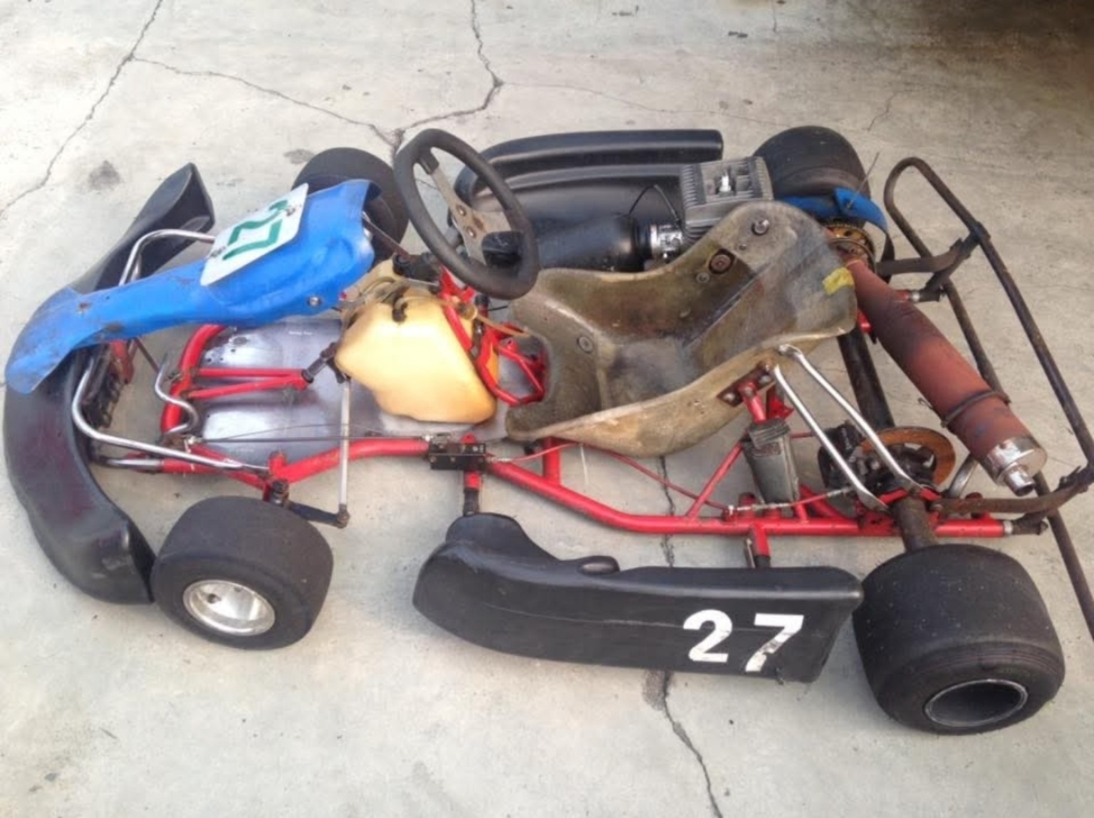 Blue and red go-kart number 27 parked on concrete