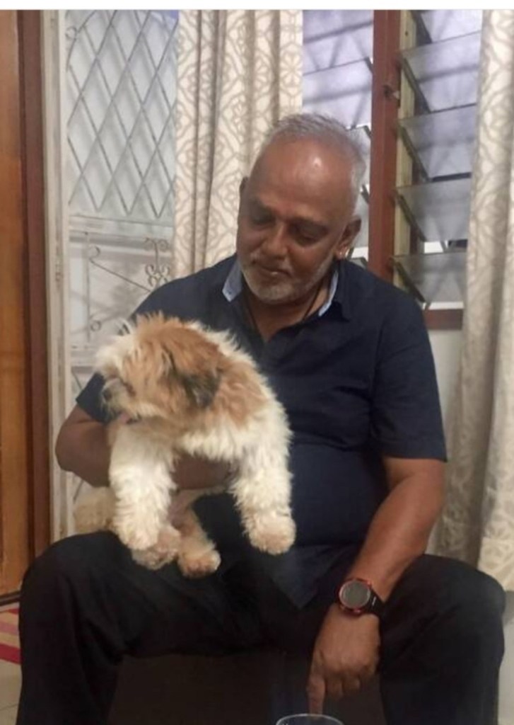 Appa holding the family dog while seated at home