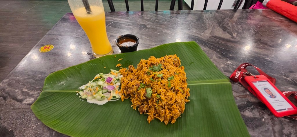 Briyani and raita served on a banana leaf.