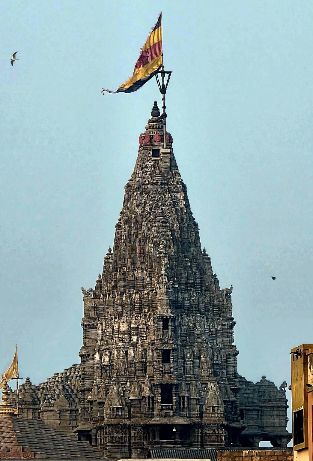 Dwarkadhish Temple stone tower with a colourful flag flying above it