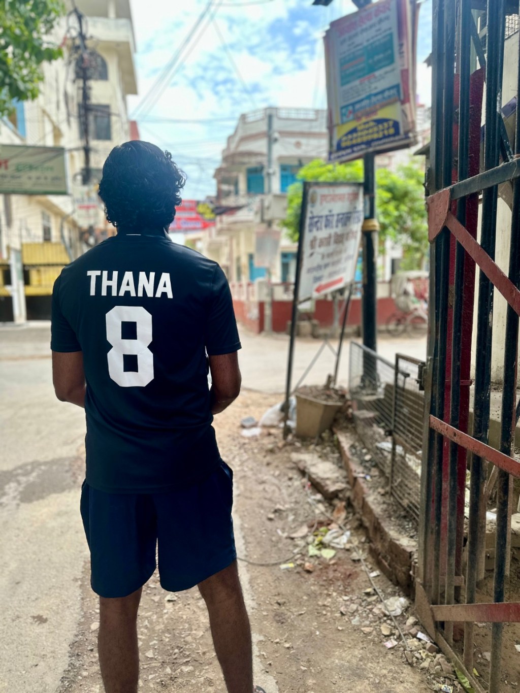 Thana wearing his number 8 jersey in a street in Kashi.