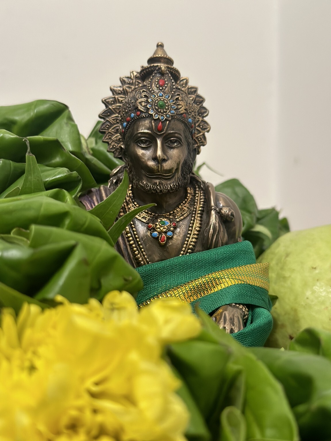 Hanuman statue obtained in Bodh Gaya, decorated with green cloth and flowers