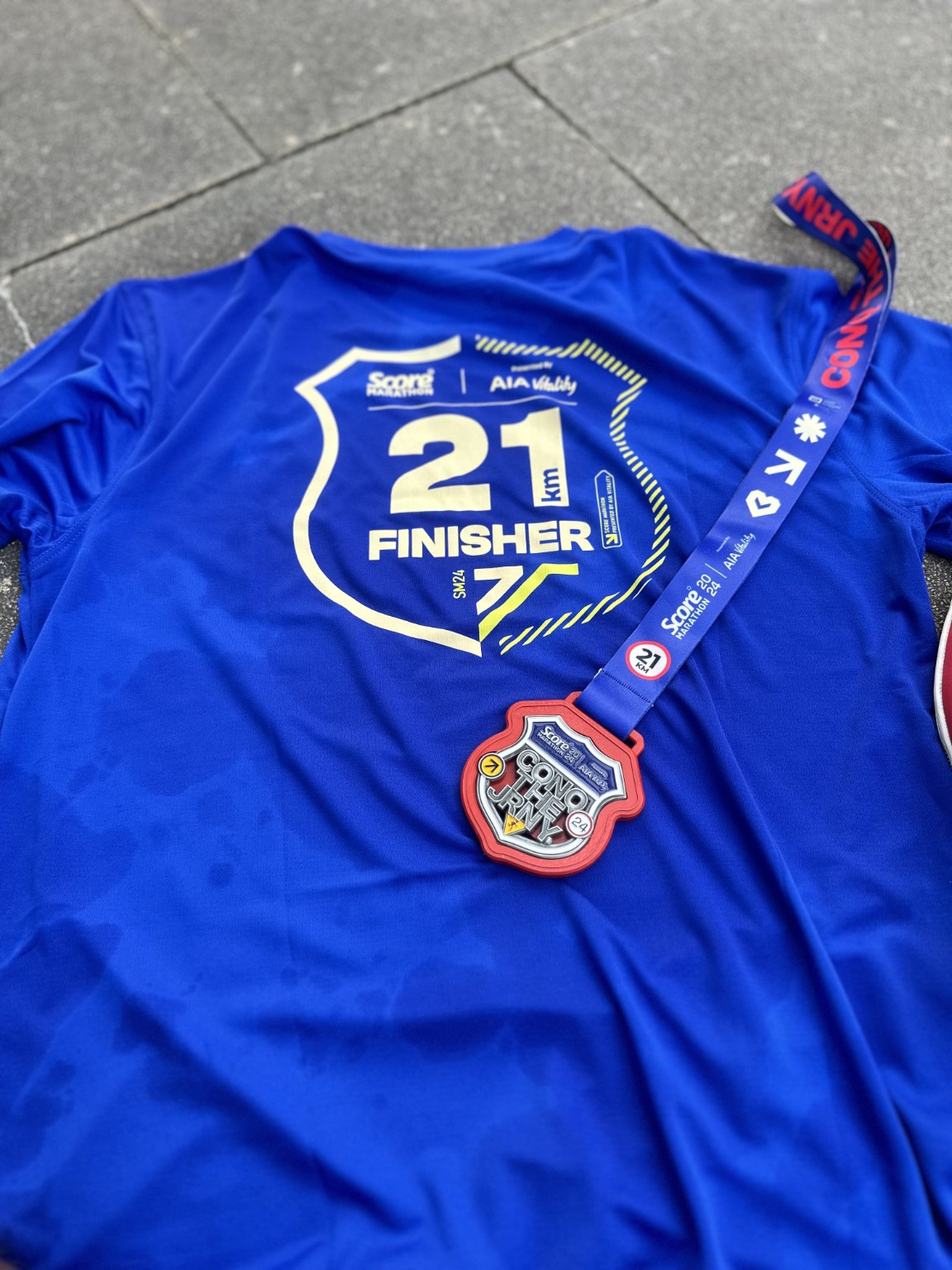 Blue 21km finisher shirt and medal from SCORE Marathon 2024.